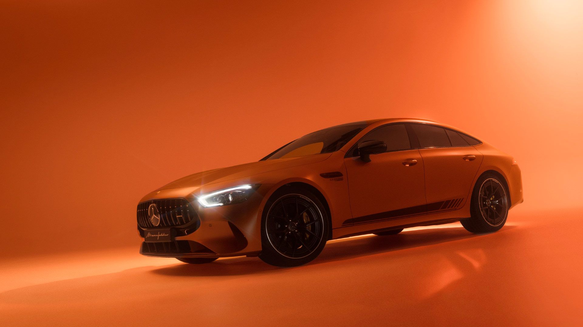 Ein Mercedes-AMG GT 4 Türer Coupé in orangenem Licht getaucht.