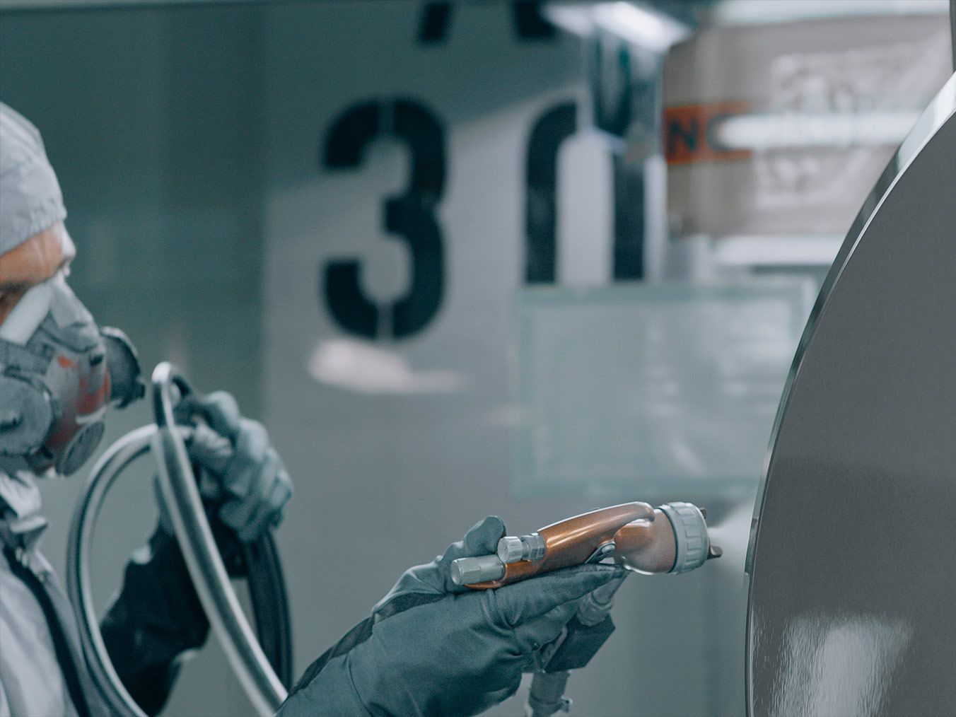 Teilauschnitt einer Person bei Lackierarbeiten.