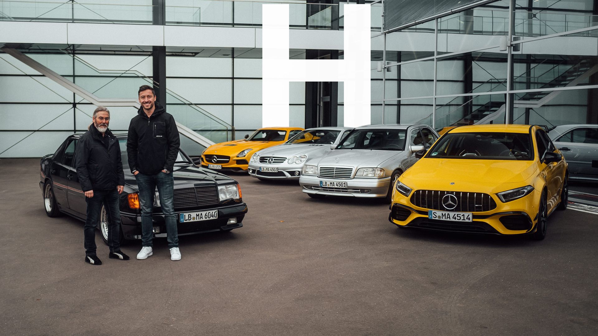 Felix and Michael in front of several Mercedes-AMG models in Affalterbach