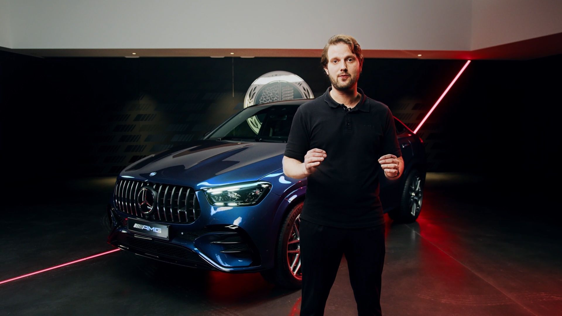 Product manager standing in a show room in front of the Mercedes-AMG GLE 53 Coupé