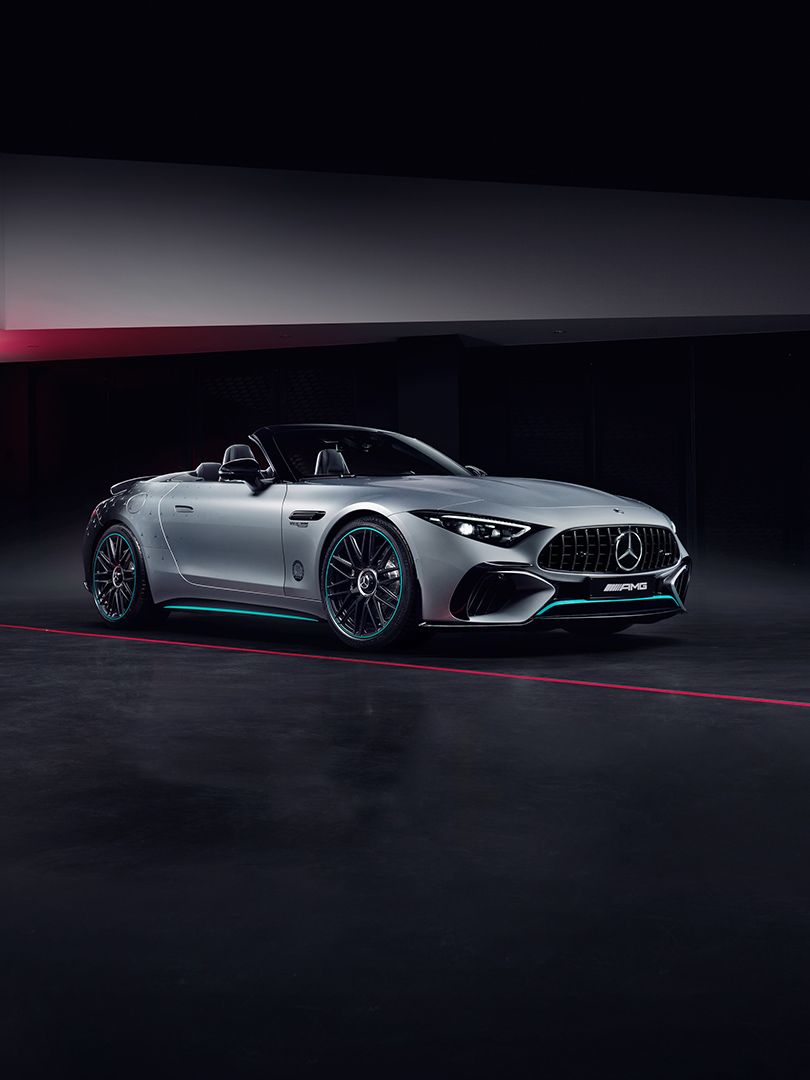 Silberner Mercedes-AMG SL 63 mit AMG Wappen im Hintergrund