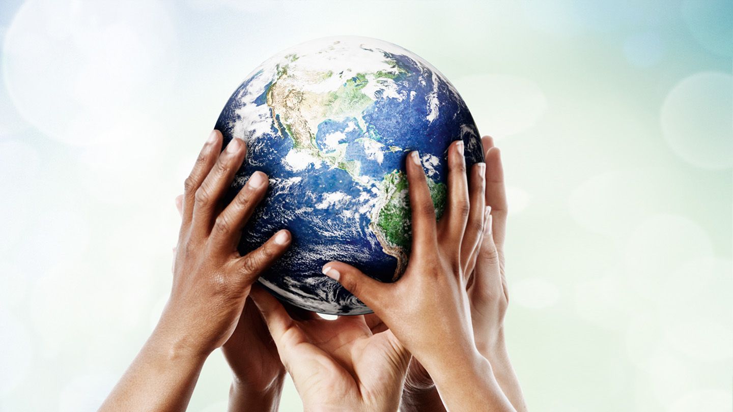 A globe carried by many hands.