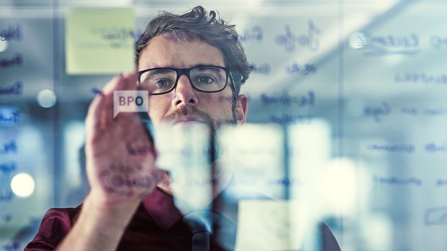 A man standing in front of a transparent white board.