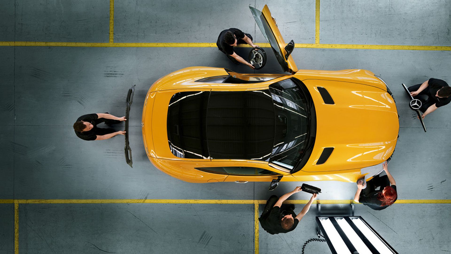 Yellow Mercedes-AMG vehicle with technicians in bird's eye view