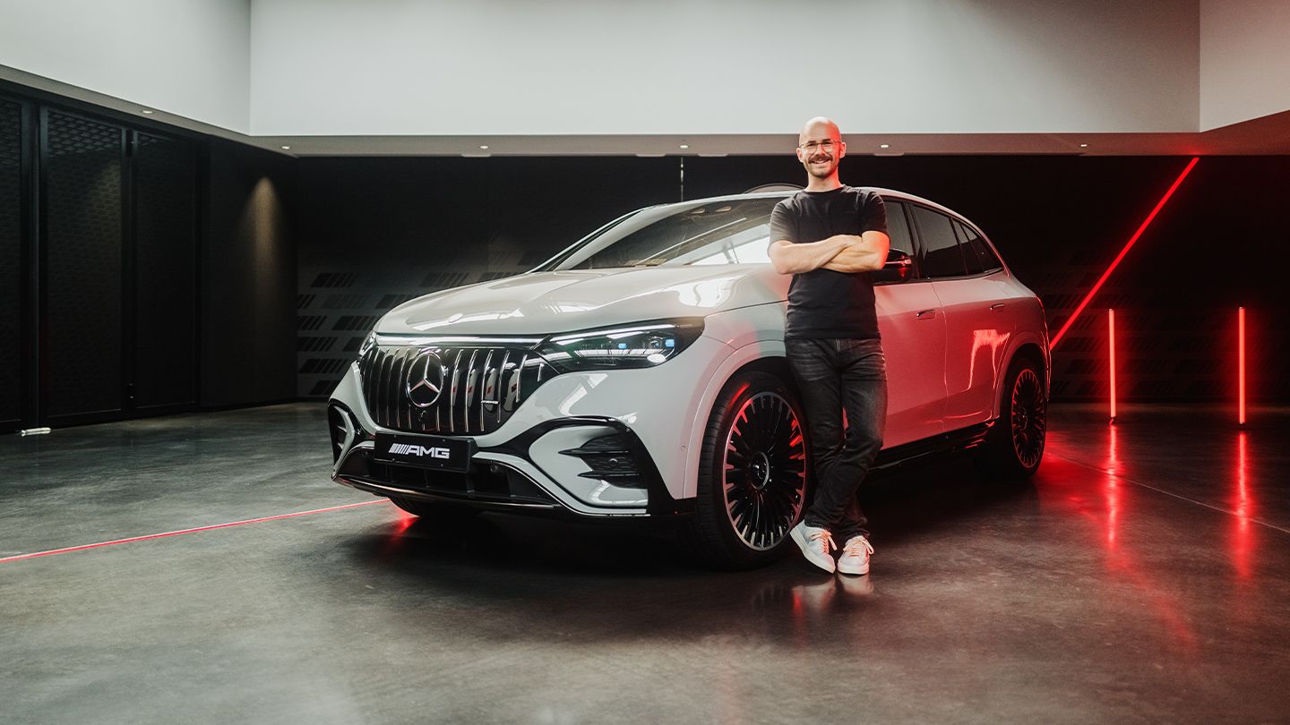 The product manager standing next to a Mercedes-AMG EQE 53 4MATIC+ SUV.