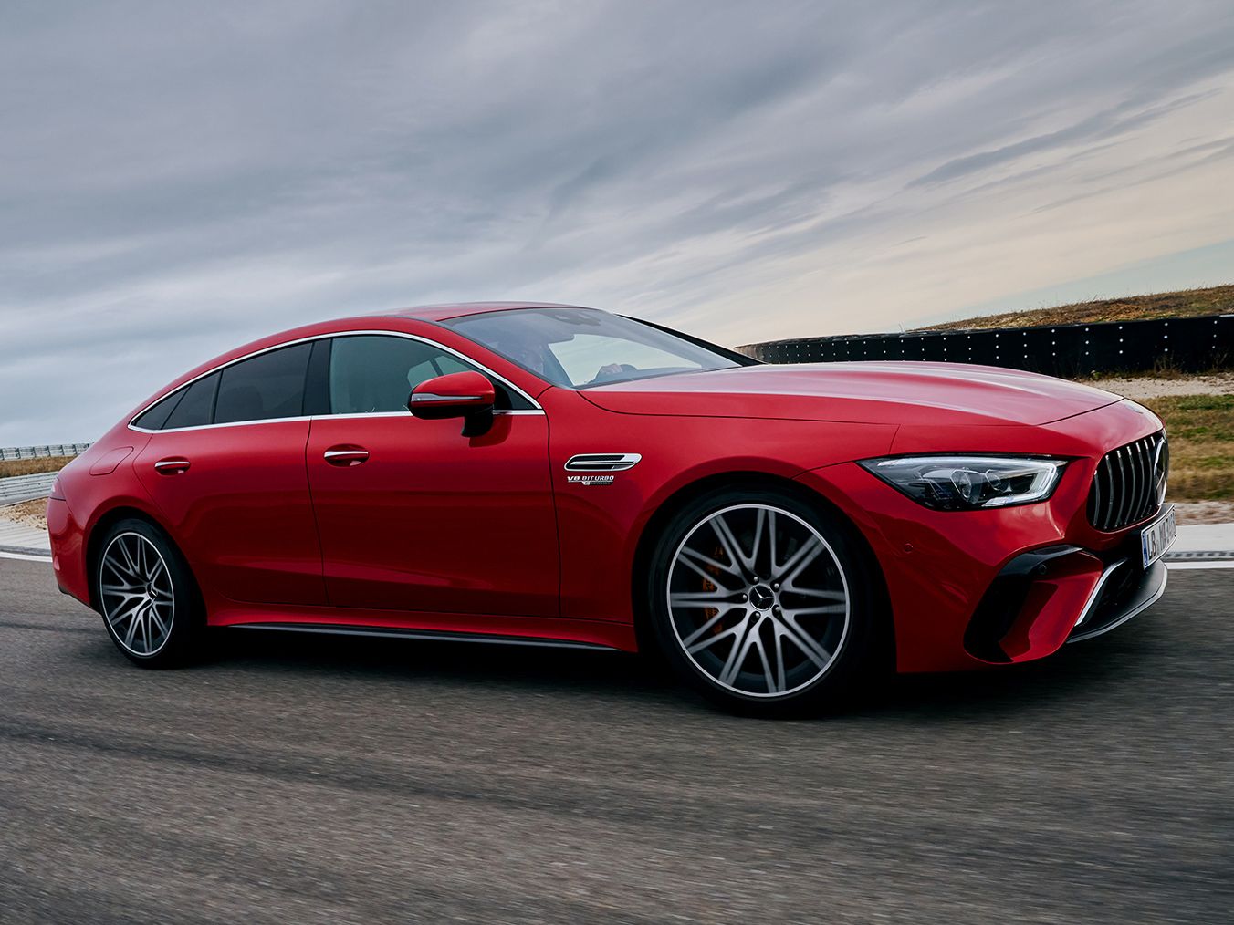 A red Mercedes-AMG GT 63 S E drifting through a curve